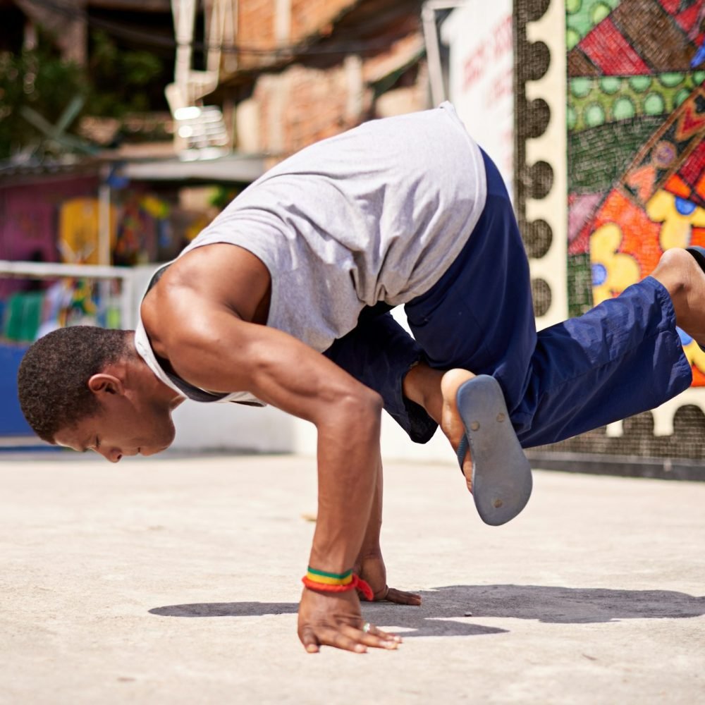 Capoeira culture. Low angle shot of a young male breakdancer in an urban setting.